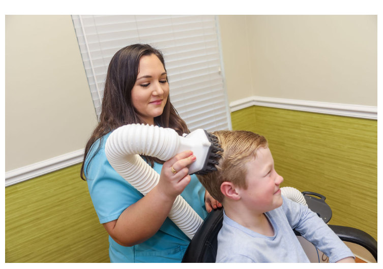 Patient receiving lice treatment from a nurse